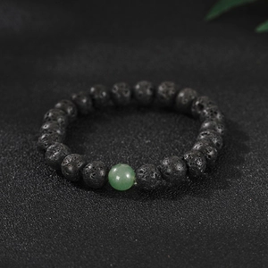 Close-up of black porous lava rock beads and a translucent green aventurine stone bracelet