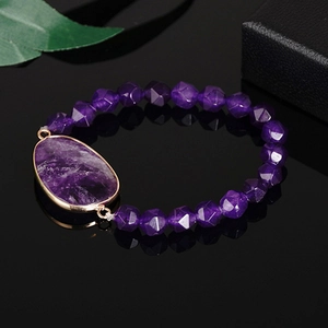 Bracciale elastico in ametista con gemma viola bordata d'oro su sfondo nero riflettente
