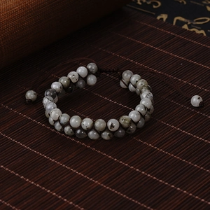 Close-up of double-layered natural stone beads on a handmade woven adjustable bracelet