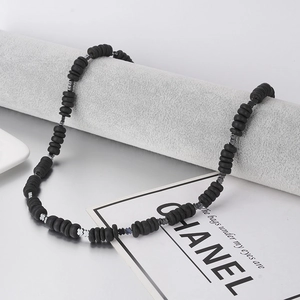 Bohemian kralenketting voor heren met natuursteen en zilveren klaverhanger op display
