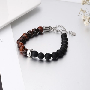 Macro view of men's punk tiger eye bead bracelet with matte black beads and silver clasp