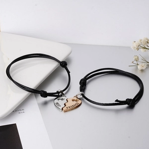 Detail of adjustable couple bracelets with gold and silver magnetic heart pendants