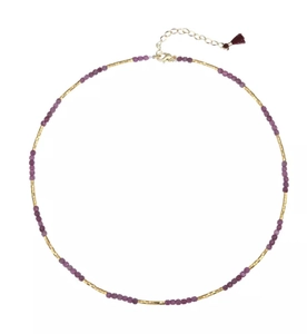 Detail of long tassel necklace with fuchsia natural stones and gold metal beads