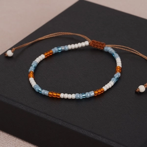 Handgefertigtes Boho-Perlenarmband mit verstellbarer Kordel auf schwarzer Geschenkbox