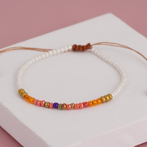 Handgefertigtes Boho-Armband mit weißen Perlen, bunten Akzenten und verstellbarem braunem Band