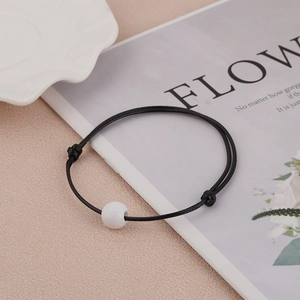 Minimalistische zwart-witte geweven armband met verstelbare schuifknoop voor elke polsomvang