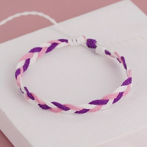 Close-up of bohemian purple, pink, and white hand-woven adjustable tassel bracelet