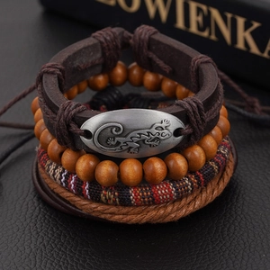Macro view of four-piece leather bracelet set featuring vintage lizard metal charm
