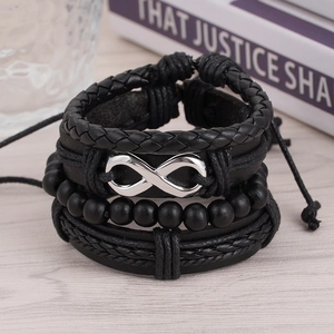 Detail eines mehrlagigen Lederarmbands mit silbernem Unendlichkeitssymbol auf Holz