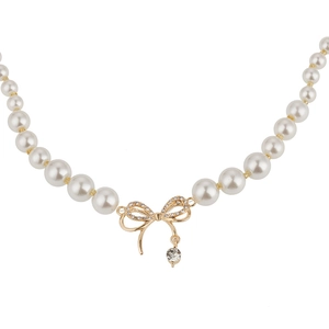 Collier de perles élégant avec pendentif nœud doré et cristaux micro-incrustés scintillants