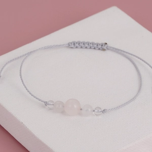 Detail of pink crystal beaded yoga bracelet with adjustable grey braided cord