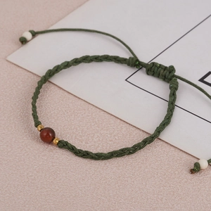 Handmade green woven bracelet with center brown stone bead and adjustable sliding knot
