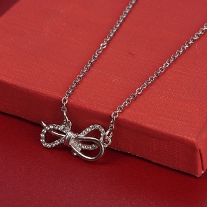 Elegant silver bow pendant necklace with sparkling rhinestones in a red gift box