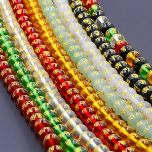 Detailed view of colorful mantra beads featuring golden religious symbols for DIY jewelry