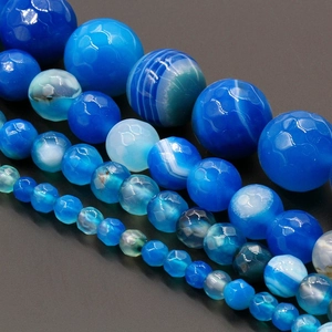 Macro detail of faceted blue agate beads showing natural banded textures and polished finish