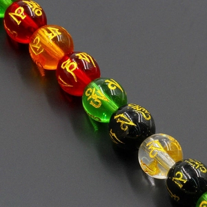 Detailed close-up of natural crystal beads with golden Six-Word Mantra engravings