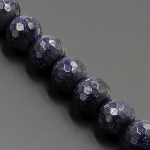 Vista dettagliata di perle sfaccettate in pietra del sole blu scuro con glitter scintillanti