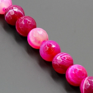 Macro detail of natural faceted agate beads with vibrant rose red and purple dragon vein patterns