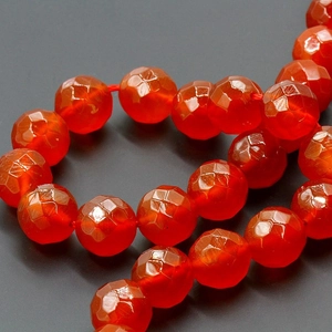 Macro shot of faceted red agate beads with vibrant orange-red hue and transparent texture