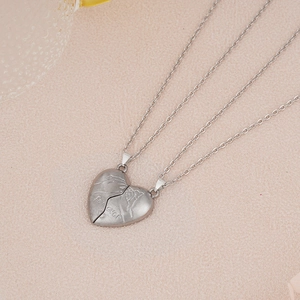 Detail of magnetic half-heart puzzle necklaces for couples with Forever engraving