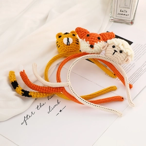 Detailed close-up of handmade knitted animal headbands featuring tiger, fox, and sheep designs