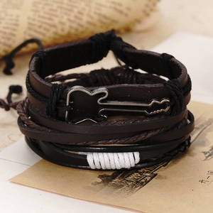 Detail shot of vintage leather bracelets featuring a retro silver guitar metal charm