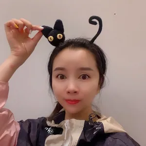 Close-up of handmade knit black cat headband featuring 3D ears and yellow eyes