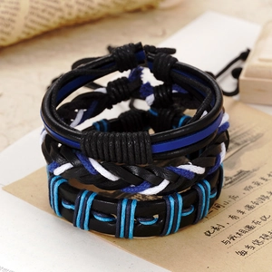 Detail of three-piece vintage woven black leather bracelet set with blue accents
