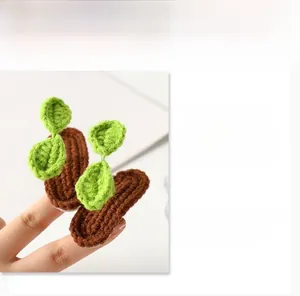 Close-up detail of a handmade knitted green sprout hair clip with crochet yarn texture