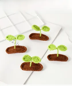 Close-up of four handmade crochet green sprout hair clips with brown soil bases
