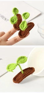 Detail of handmade crochet green sprout hair clips on white ceramic cup and fingers