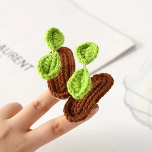 Handmade crochet green sprout hair clips showing adorable 3D leaf design on fingertips