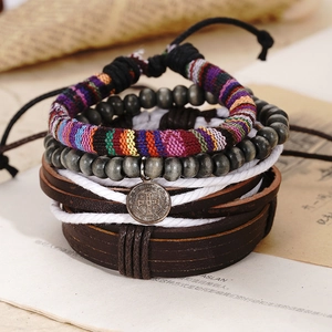 Detail of vintage hand-woven leather bracelet set with silver medal on retro magazine