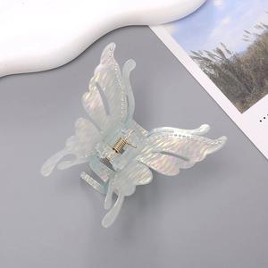 Détail de la pince à cheveux papillon irisée avec strass et texture diamantée
