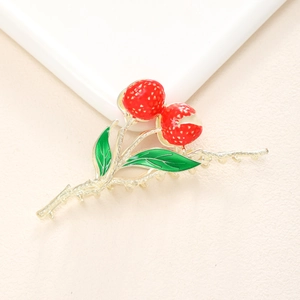 Détail macro d'une pince à cheveux fraise dorée avec fruits rouges et feuilles vertes