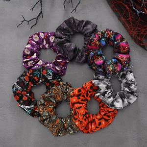 7-piece Halloween scrunchie set with pumpkin and skull prints on a dark textured background