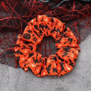 Halloween scrunchie with orange pumpkin and witch pattern on spider web background