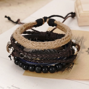 Close-up of four handmade leather bracelets featuring a vintage silver feather charm