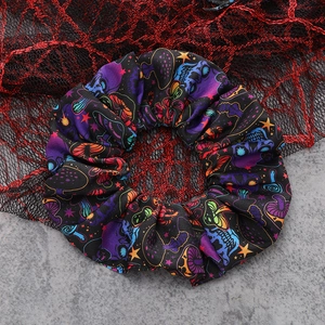 Close-up of gothic Halloween scrunchie featuring colorful skull and mushroom patterns