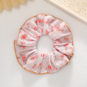 Gros plan du chouchou floral avec motifs de roses roses et bordure en soie kaki