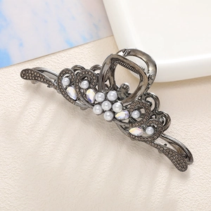 Detalle de una pinza para el pelo vintage de metal con cristales y perlas blancas