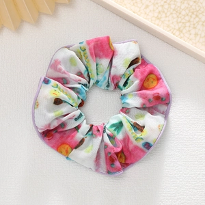 Détail du chouchou floral coloré avec bords violets et texture de tissu élastique