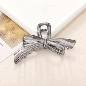Vista de detalle de pinza para el pelo tipo mariposa en metal gris oscuro con strass