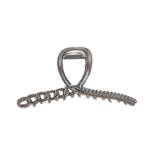 Detalle de pinza para el pelo de metal con pedrería marrón y dientes de sujeción fuertes