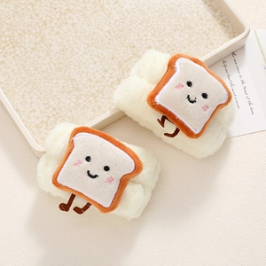 Macro shot of soft white plush face washing wristbands with cute toast cartoon detail