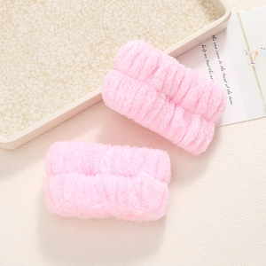 Detailed view of pink plush absorbent wristbands for washing face in soft coral fleece