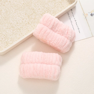 Detail of pink coral fleece wrist washbands with soft plush absorbent texture and ribbed design