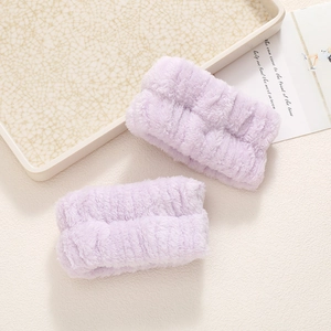 Close-up of soft purple coral fleece wristbands for washing face to prevent water splashes