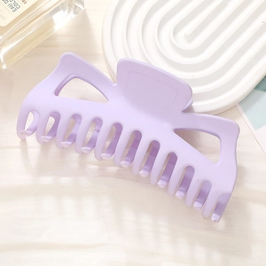 Close-up of a matte lavender oversized hair claw clip on a soft white mesh background