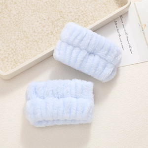 Close-up of light blue plush wristbands with vertical striped texture for face washing